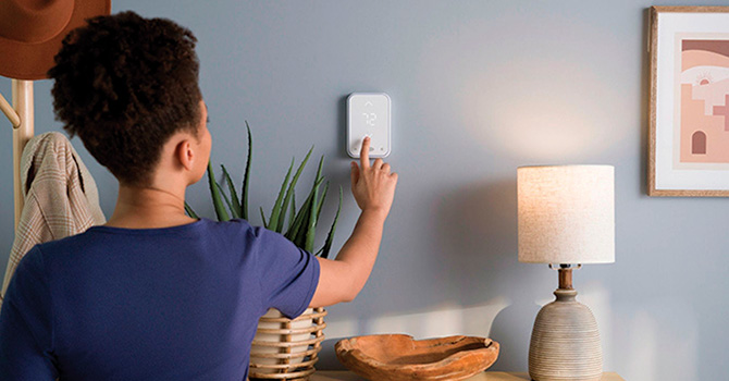 woman adjusting thermostat