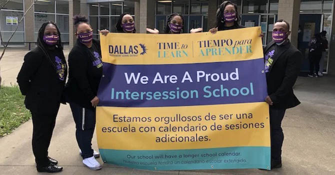 Dallas ISD campus leadership teams holds a banner